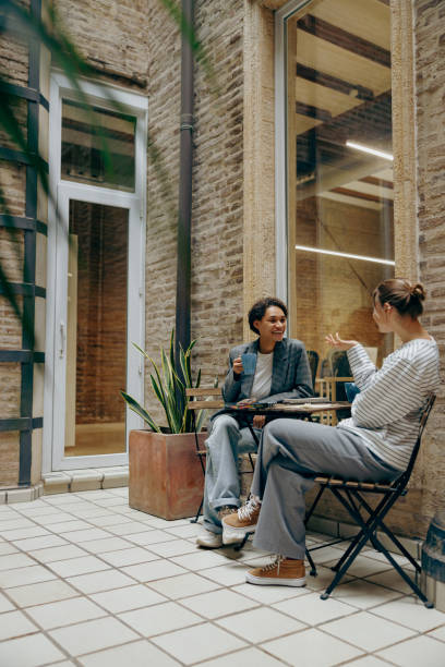 istock Two female colleagues have a coffee break time while sitting on office terrace 2116994378
