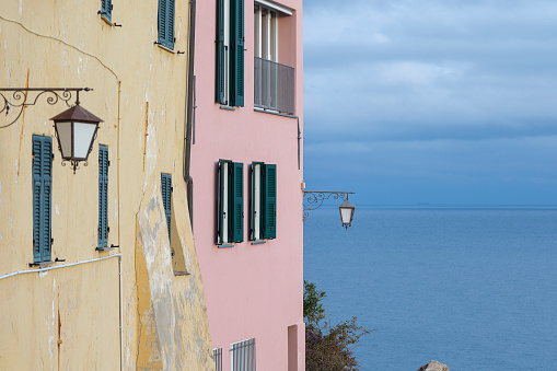 External facade of colorful houses with the sea in the background. Liguria, Italy.