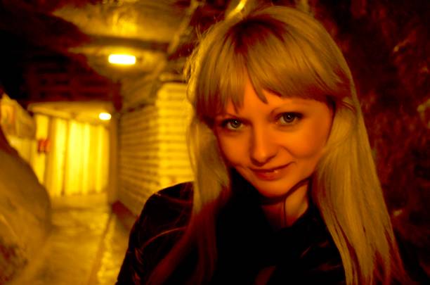 Woman walking into a corridor tunnel towards darkness. Concept about unknown and mystery.