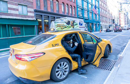 Greenwich village, Manhattan, New York, USA - March, 2024. Yellow cab picking up a passenger in Greenwich Village, Manhattan, New York.