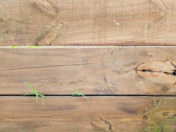 istock Texture of rustic woods arranged horizontally with grass peeking out. 2117030821