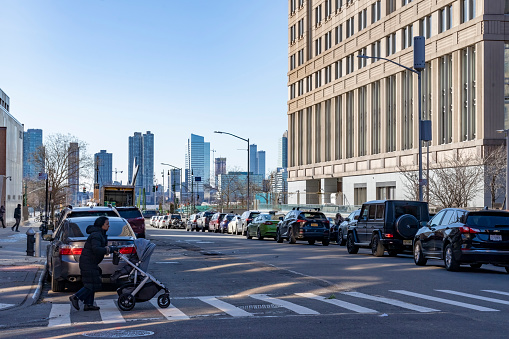 Greenwich village, Manhattan, New York, USA - March, 2024. A mother with a baby stroller on a crossing in Greenwich Village.