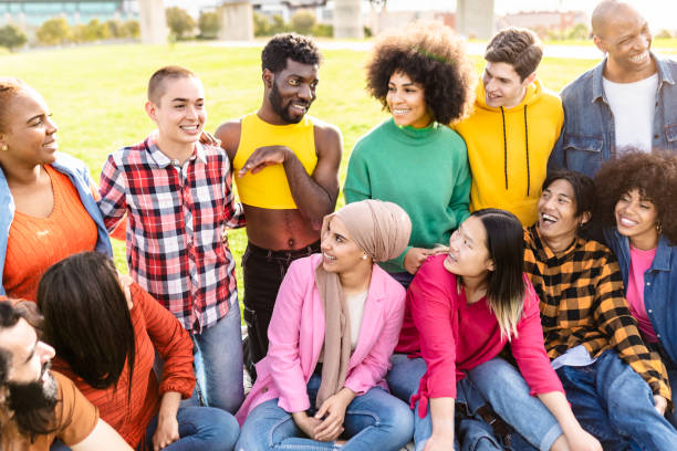 istock Happy young multiracial people having fun sitting on grass in a public park - Diversity and friendship concept 2117054246