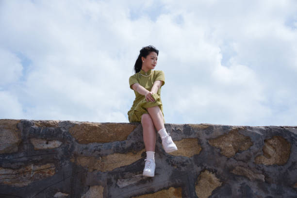 istock girl sitting on wall 2117063836