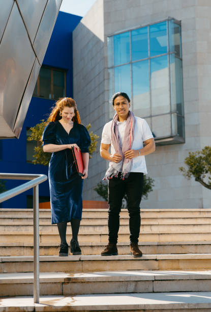 istock Two creative professionals descending stairs outdoors. 2117075043