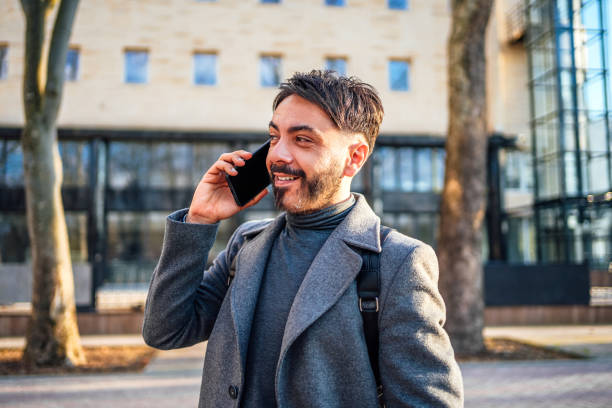 istock Man talking on the phone while walking in the city 2117076273