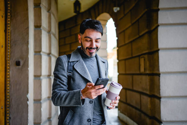 istock Mid adult man using phone outdoors 2117082364