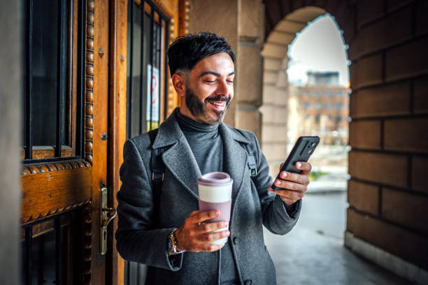 istock Mid adult man using phone outdoors 2117083398