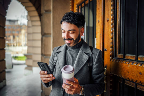 istock Mid adult man using phone outdoors 2117084439