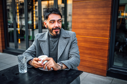Smiling man enjoying while drinking coffee in a café