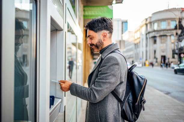 istock Man using an ATM in the city 2117091804