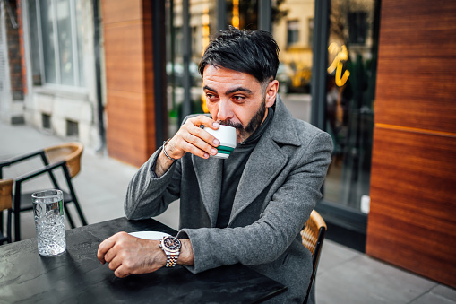 Man enjoying while drinking coffee in a café