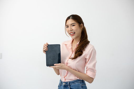 Digital Communication: Asian Woman Holds Touchscreen Tablet on White Background, Embracing Connectivity in Modern World