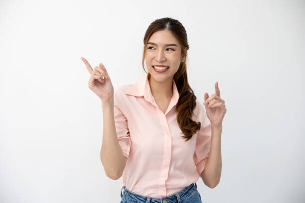 istock Presentation Concept: Asian Woman Demonstrating Gesture, Pointing to Space on White Background, Creative Expression of Ideas 2117117334