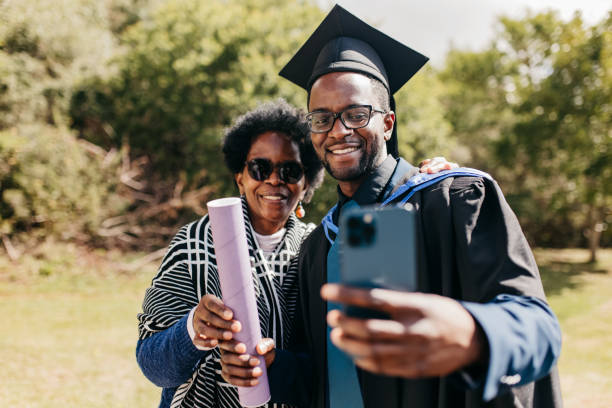 istock Proud young man taking selfie with mother on graduation day at campus grounds 2117118415