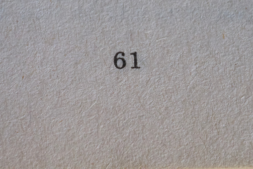 The number 61 printed on a piece of paper. Paper texture.