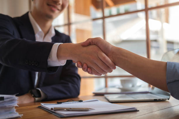 istock Businesspeople shaking hands in office. 2117151331