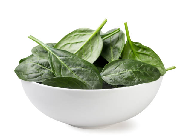 istock Spinach leaves in a plate close-up on a white. Isolated 2117152942