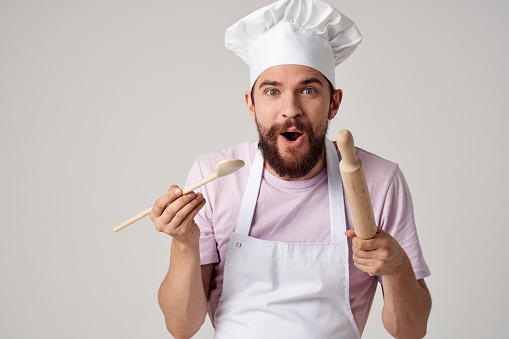 emotional male chef in a white apron is trying food. High quality photo