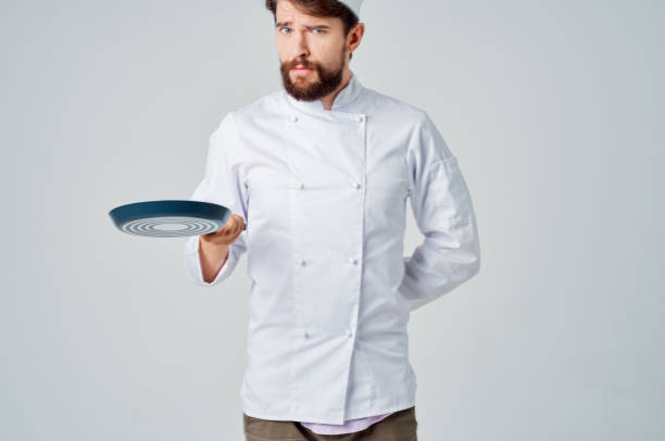 istock bearded man chef with a frying pan in hand isolated background 2117180200