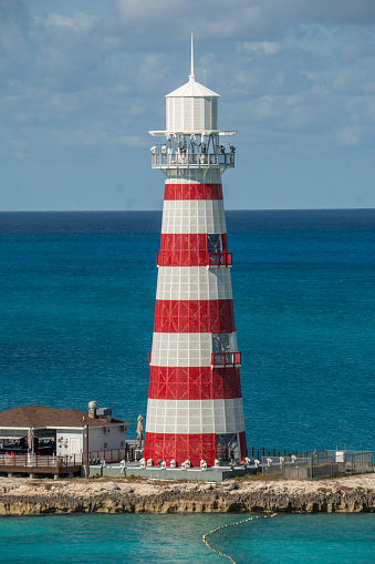Lighthouse in the middle of the caribbean sea on the MSC Island. Blue water and blue sky in the background.