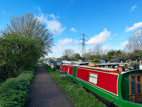 Canal boats mored along the River Lee Navigation canal in Tottenham, London. March 2024