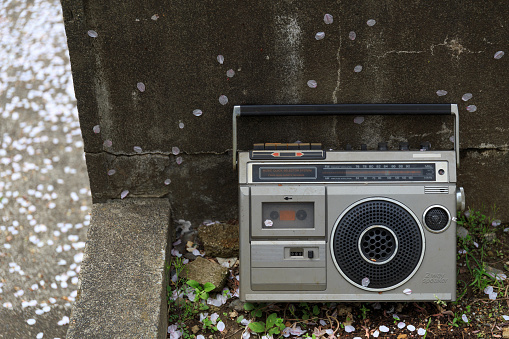 An old boom box propped up in a garbage collection area