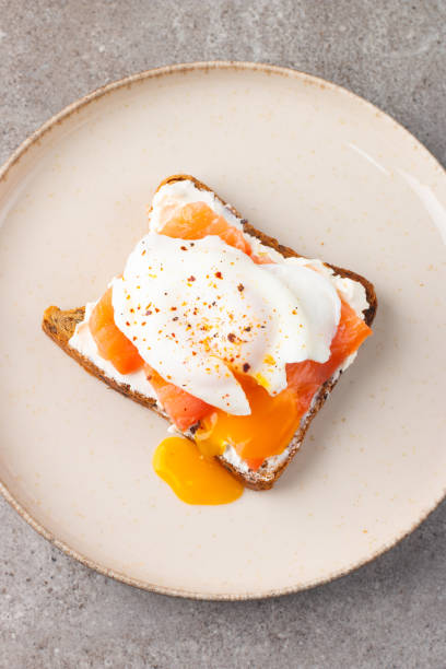 istock Poached egg on salmon and cheese toast. Breakfast food concept. Open sandwich. 2117238887
