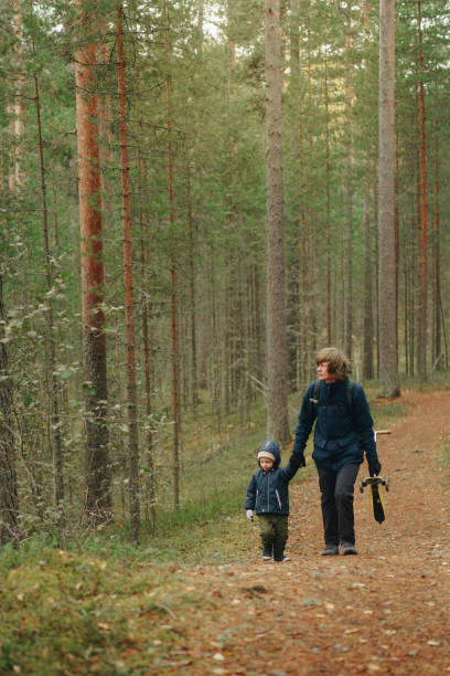 istock father and sons walking in the woods. 2117246498