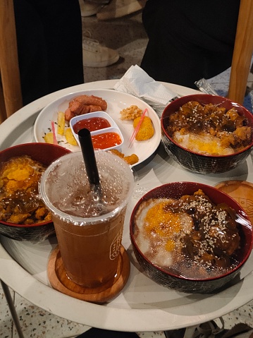 A photo shows delicious dishes beautifully presented on a cafe table, with bright colors and attractive contrasts, inviting the taste buds and creating a warm and pleasant atmosphere for cafe visitors.