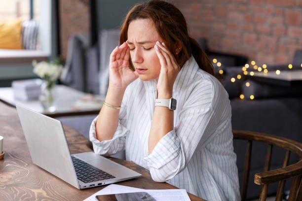 istock Young woman suffering from headache working in home office 2117263301