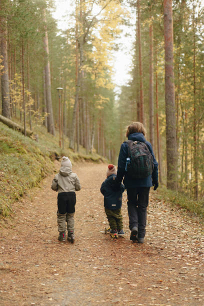 istock father and sons walking in the woods. 2117265296