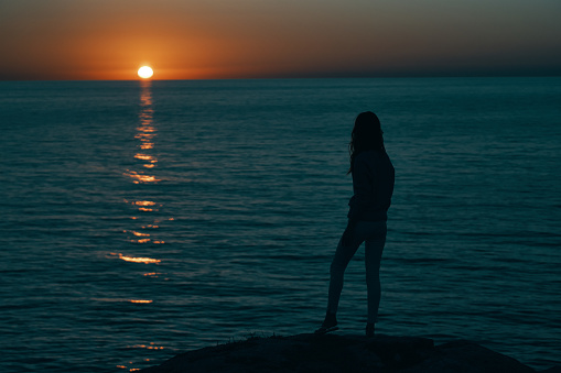 woman near the sea at sunset dark silhouette and beach model. High quality photo
