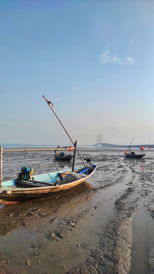 Couple old wooden boat of fisherman on the beach near by bridge during the recedes