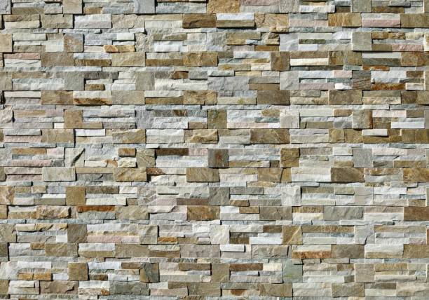 istock Large stone coating wall made of  bricks and cubes of  multicolor rocks. 2117307997