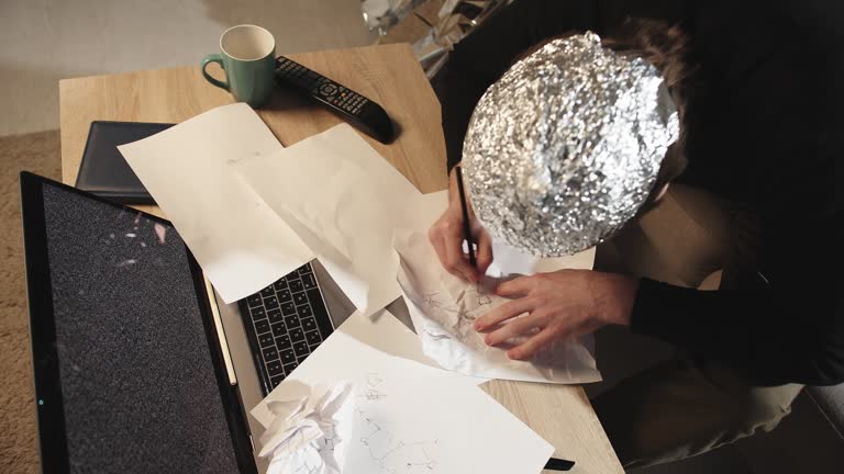 Symbolic Secrets: Man in Tin Foil Hat Sketching Esoteric Signs