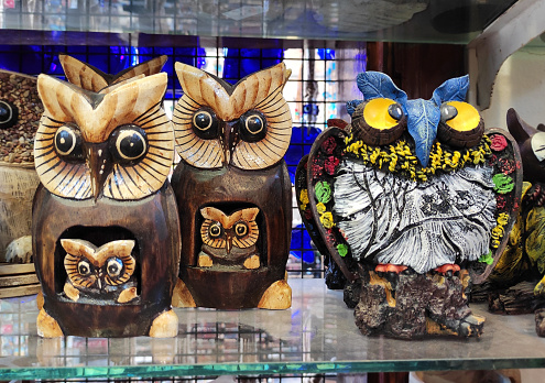 Decorative multicolored owl figurines on the shop a window