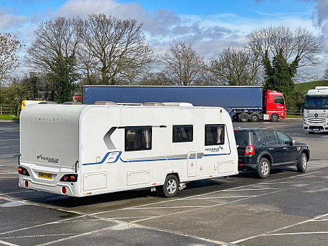 Strensham, Worcestershire, UK - 17 March 2024: Large caravan and car in the lorry parking area of the Strensham M5 motorway service station