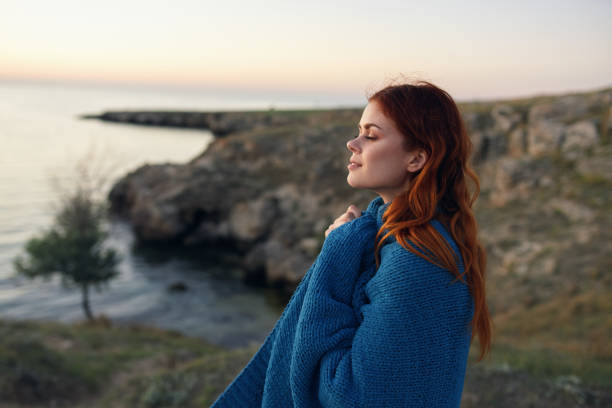 istock woman in the mountains outdoors with a blue plaid on her shoulders side view 2117419123