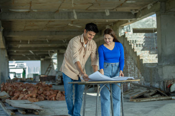 istock Couple examining blueprint at construction site 2117433009