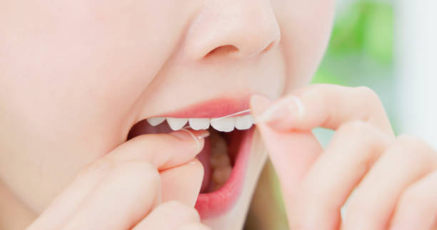 istock asian woman flossing teeth happy 2117457354