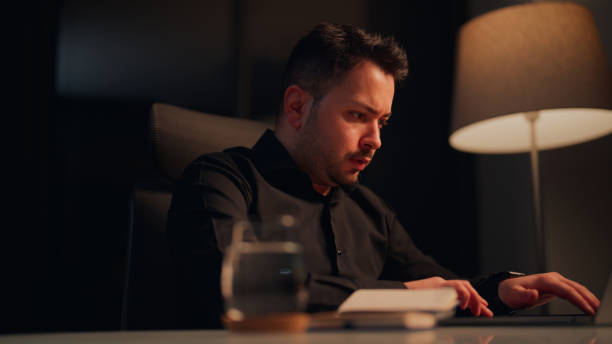 istock Businessman working late in office at night and feeling stressed 2117470803