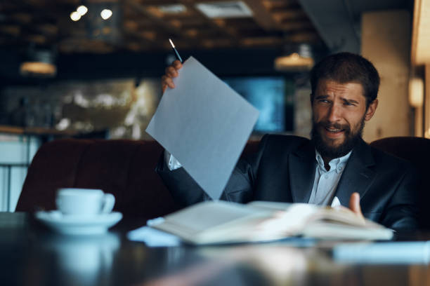 istock business man sitting at a table in a cafe documents work official coffee cup 2117472403