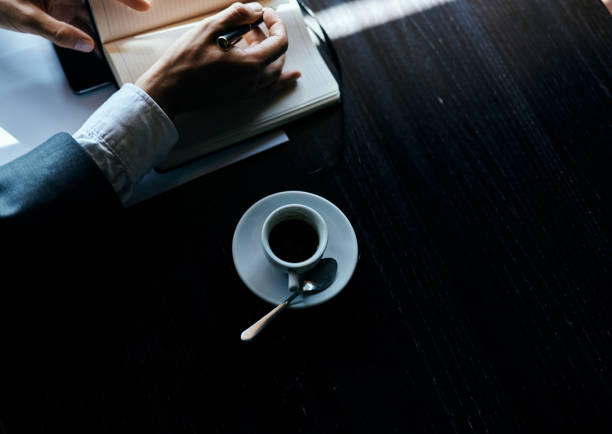 Business man in a cafe documents a cup of coffee on the table official work. High quality photo