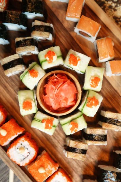 istock Wooden Table Heavily Laden With Assorted Sushi Rolls 2117549168