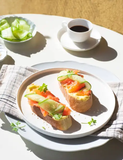 Breakfast in Scandinavian stylet: sandwiches with smoked salmon, cream cheese mousse and cucumber. Healthy natural quick recipes. Natural beautiful light