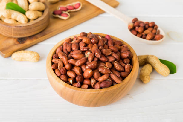 istock Fresh healthy peanuts in bowl on colored table background. Top view Healthy eating bertholletia concept. Super foods 2117561925