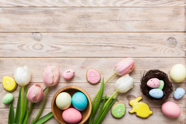istock Easter frame with eggs, gift box and tulip on a colored background. The minimal concept. Top view Happy Easter composition. Card with a copy space of the place for the text 2117562315