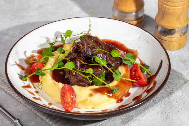istock Mashed potatoes with beef in sweet and sour sauce, decorated with tomatoes and microgreens. 2117565651