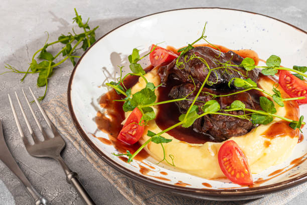 istock Mashed potatoes with beef in sweet and sour sauce, decorated with tomatoes and microgreens. 2117566696